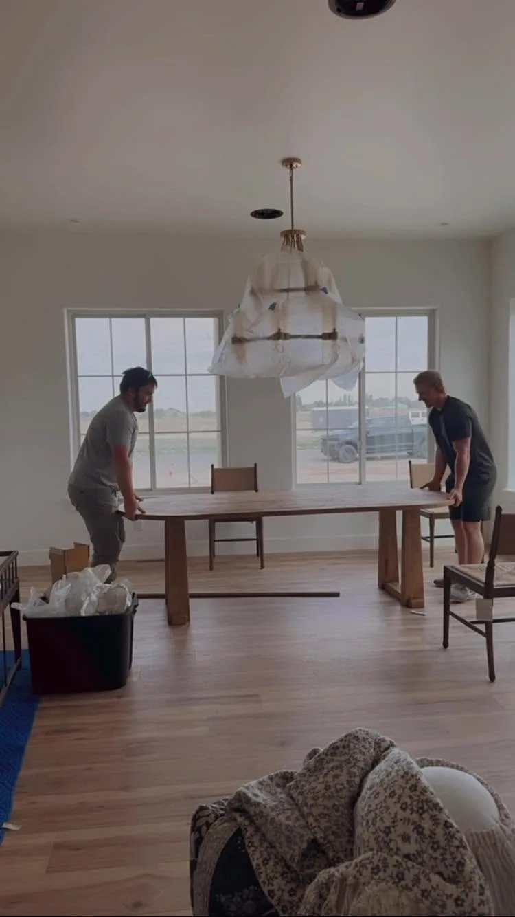 Movers positioning a table in a home
